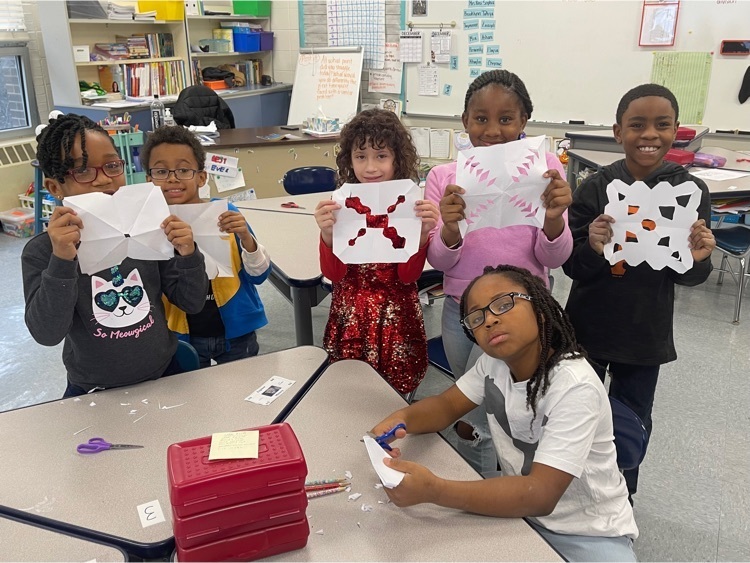 Third grade students displaying their snowflakes 