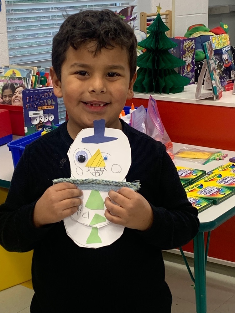 a kindergarten friend proudly showing off his snowman 