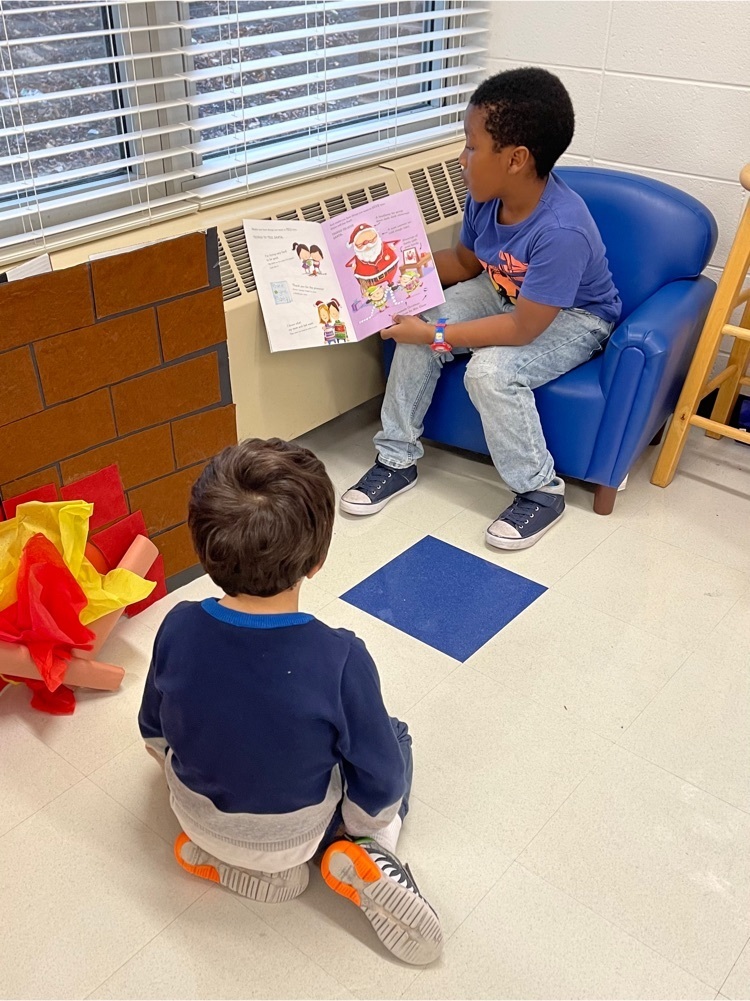 Third graders reading to PreK students 