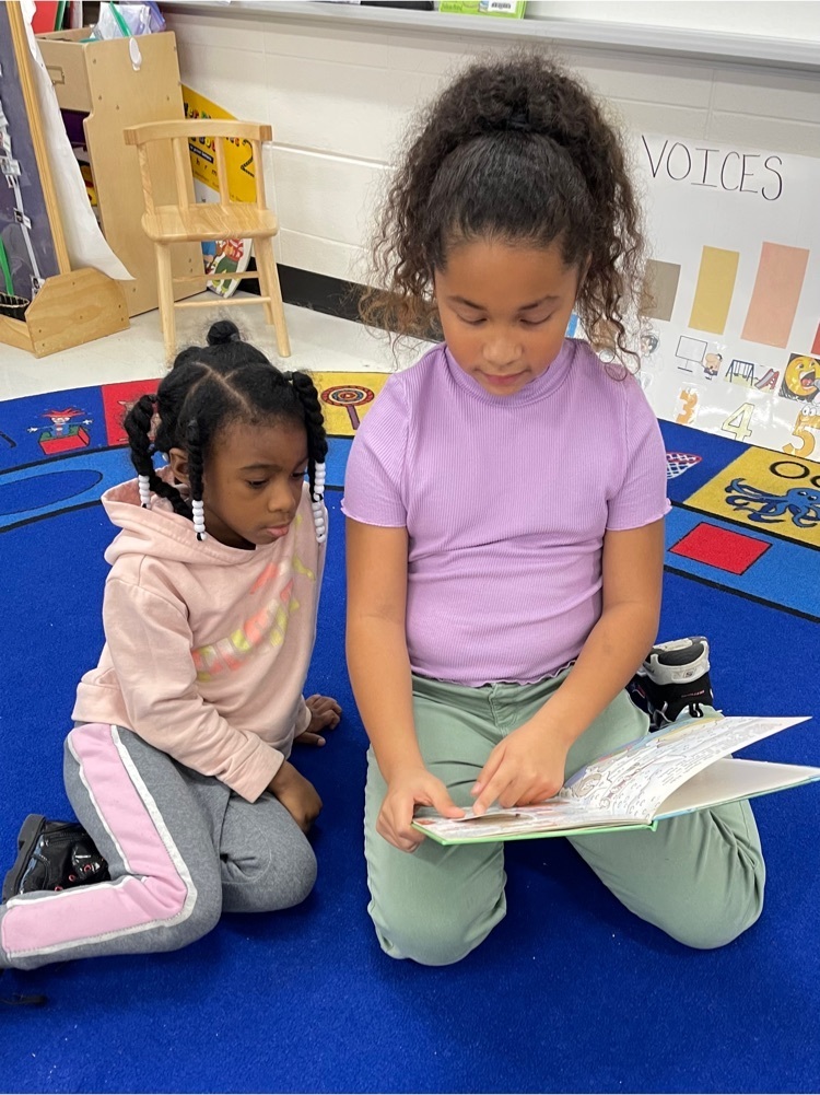 Third graders reading to PreK students 