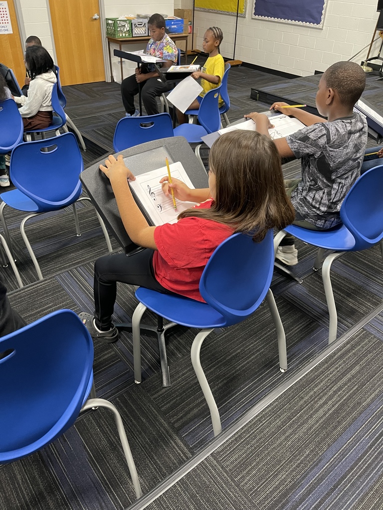 Student's filling out a guided worksheet of musical staffs